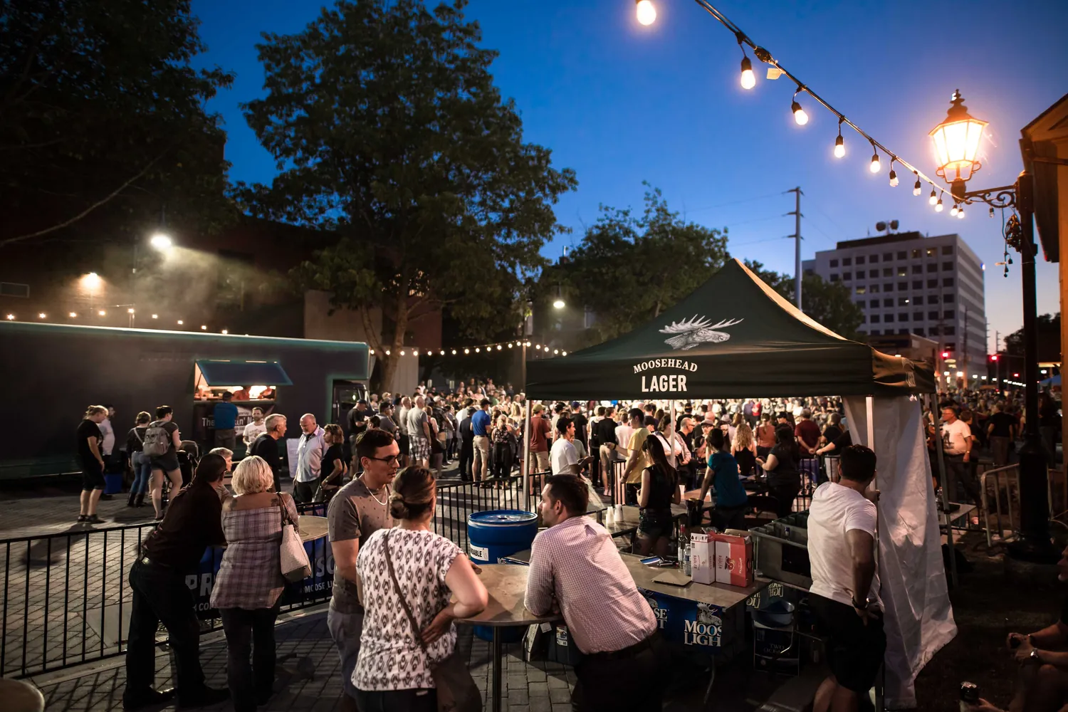 The outdoor beer garden at dusk under string lights during Harvest