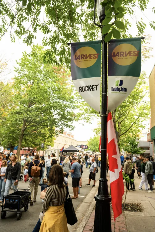Harvest Music Festival banners over the crowd on the closed-off street