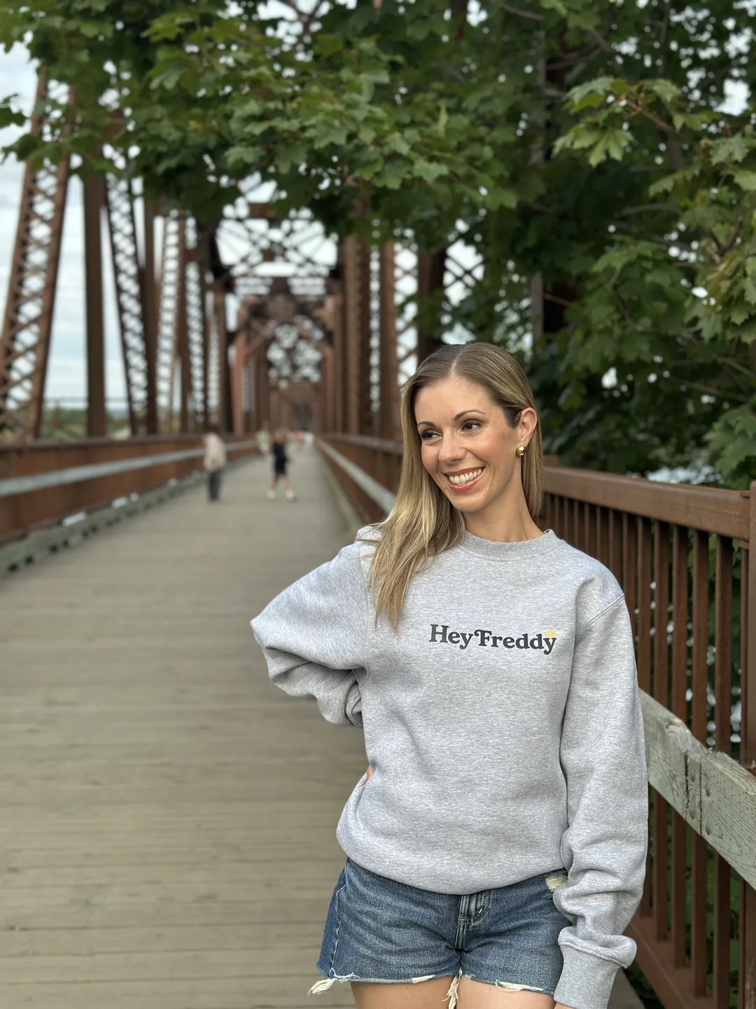 Local wearing the Hey Freddy Dad Sweater on the Bill Thorpe Walking Bridge in Fredericton
