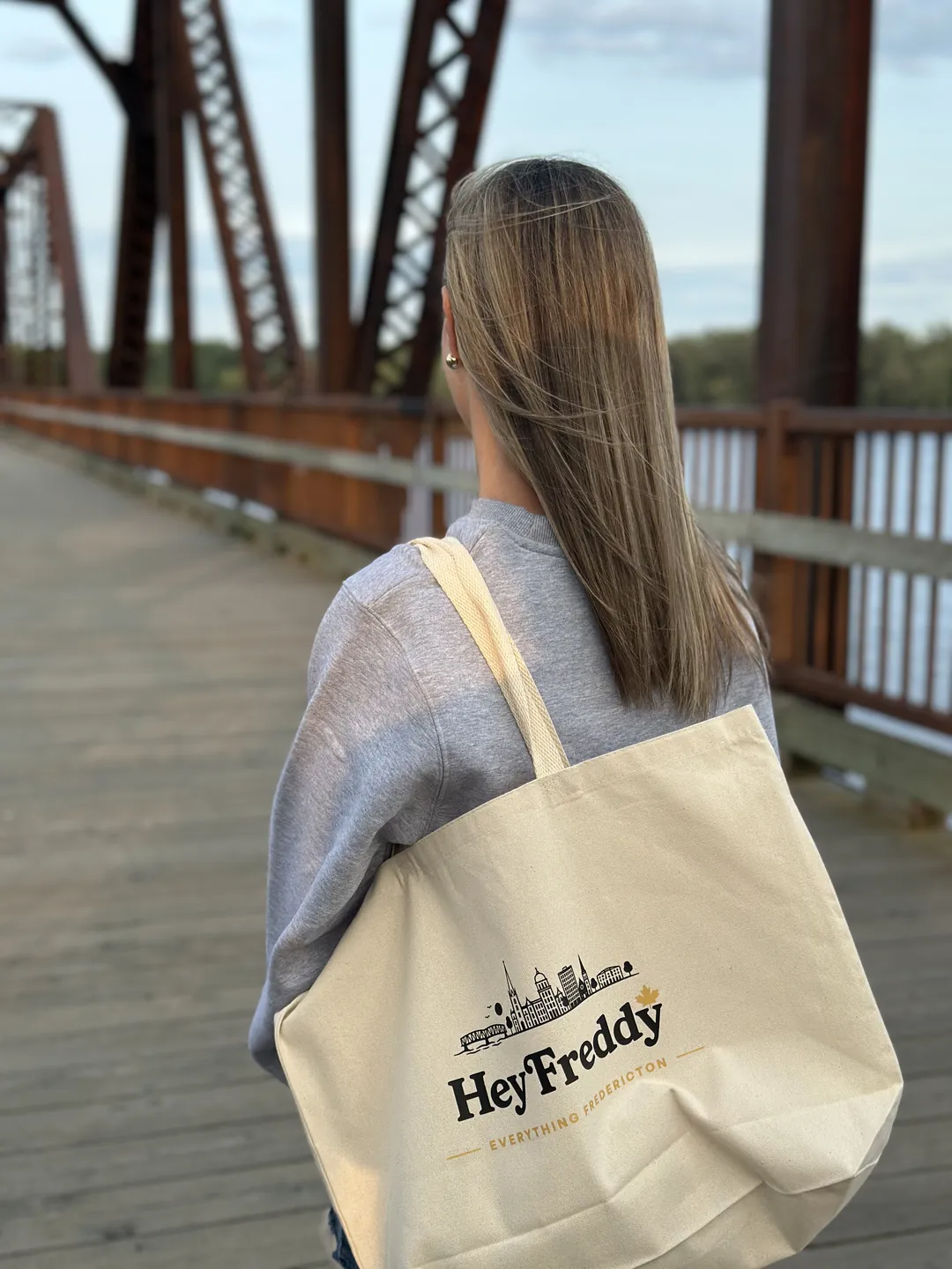 Local carrying the Everything Fredericton tote across the Bill Thorpe Walking Bridge